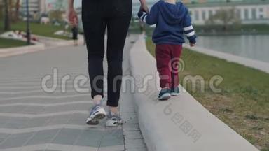 妈妈牵着宝宝的手.. 母亲和儿子正沿着长廊散步。